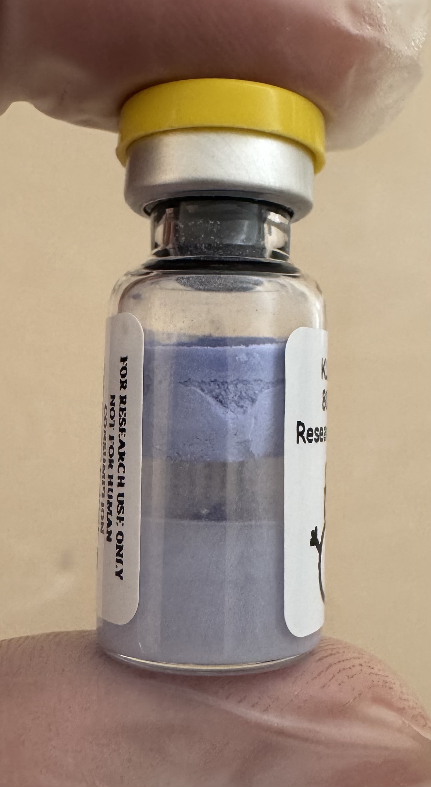 Blue-violet lyophilized KLOW (GHK-Cu + BPC-157 + KPV + TB-500) 80mg powder cake inside the sealed vial